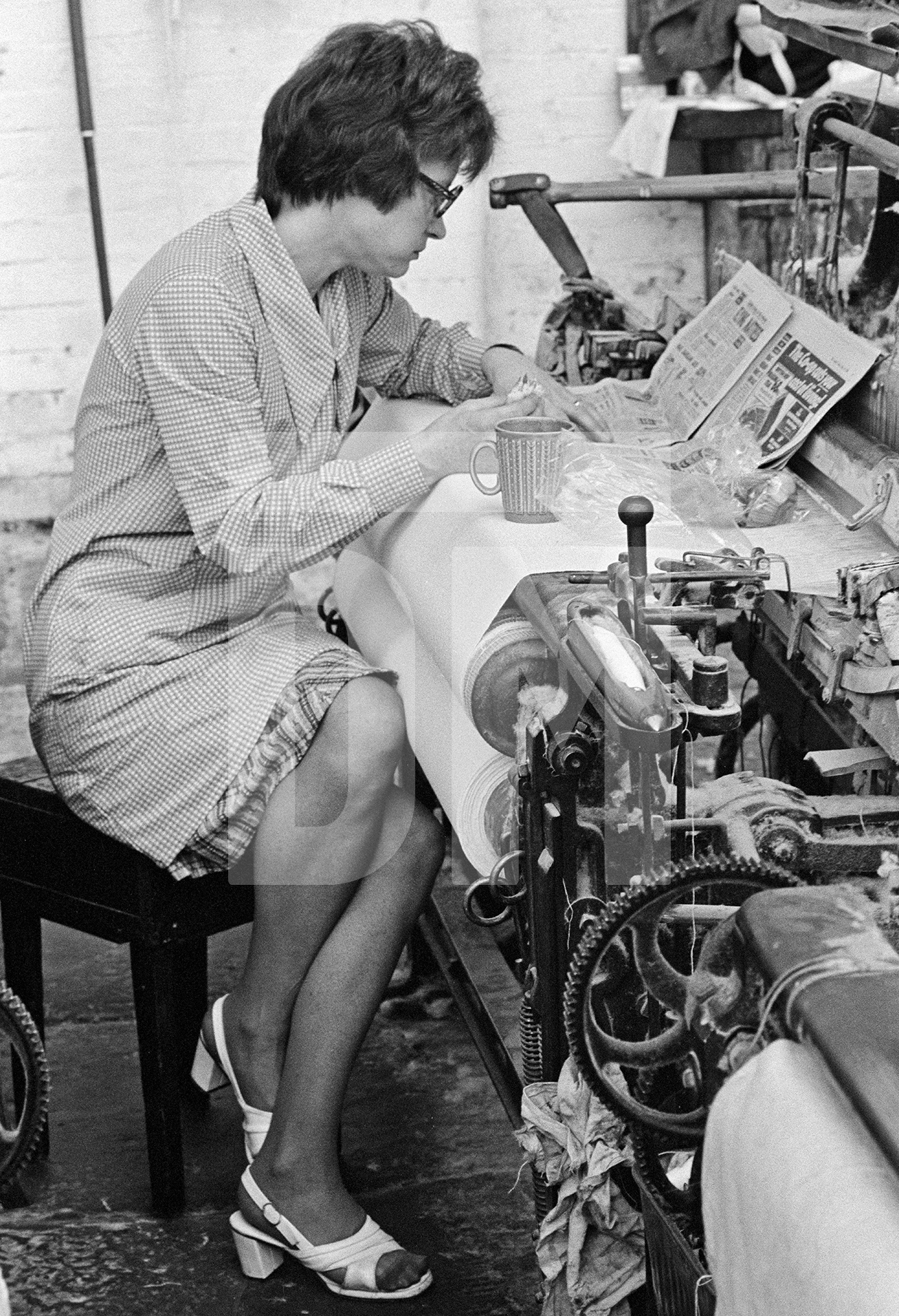 In the weaving shed, a weaver takes her break. May 1976 by Daniel Meadows