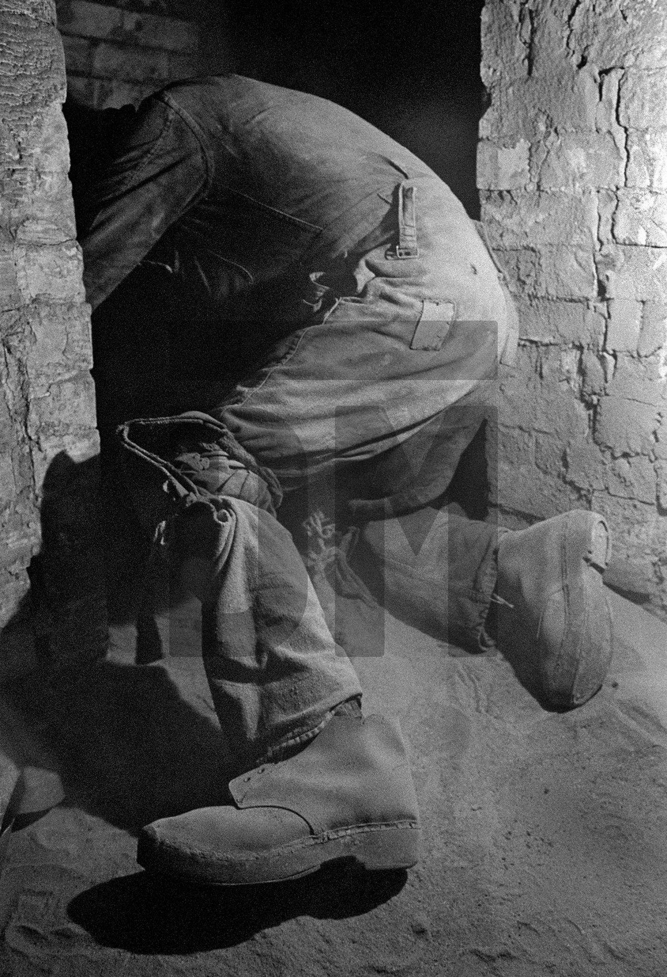 Entering the side flue from the sole flue, beneath the Lancashire boiler, while shovelling fluedust. Easter holiday, April 1976 by Daniel Meadows